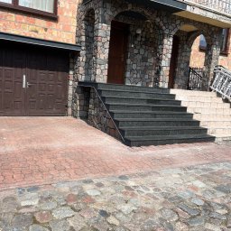 Usługi remontowe-budowlane - Wykończenie schodów wejściowych z ciemnego kamienia w Minkowicach. Kamienne obłożenie budynku i podjazdu z kostki. Estetyczne detale architektoniczne.