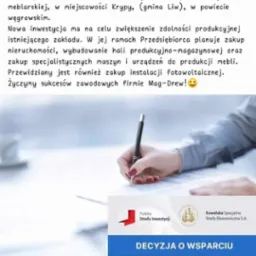 Ręka podpisuje dokument Decyzja o Wsparciu od Suwalskiej Specjalnej Strefy Ekonomicznej, dotyczący inwestycji w branży meblarskiej firmy Mag-Drew Magdalena Turemka.