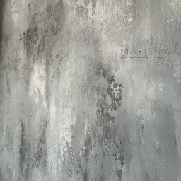 MADERA - Studio Projektowania Wnętrz i dekoracji ścian - Szara ściana z efektem dekoracyjnym, imitującym przetarcia i nierówności, z subtelnym logo „Madera” w prawym górnym rogu.