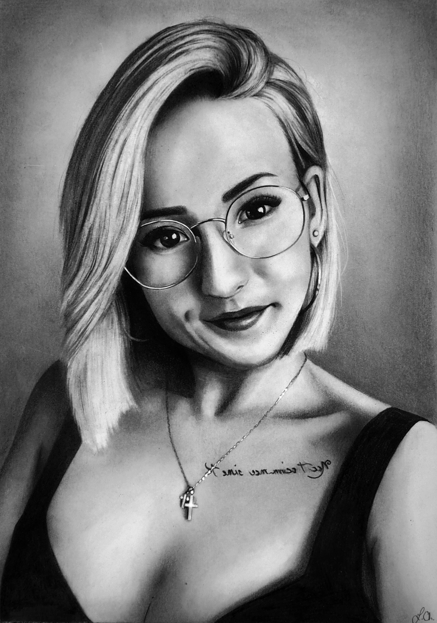 Czarno-biały portret kobiety z blond włosami w okularach, z delikatnym uśmiechem, widoczny tatuaż na dekolcie i srebrny krzyżyk na łańcuszku.