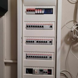 Elkam Term - Rozdzielnica elektryczna w białej obudowie, widoczne bezpieczniki i przewody, numeracja od 1 do 60, zamontowana na ścianie.