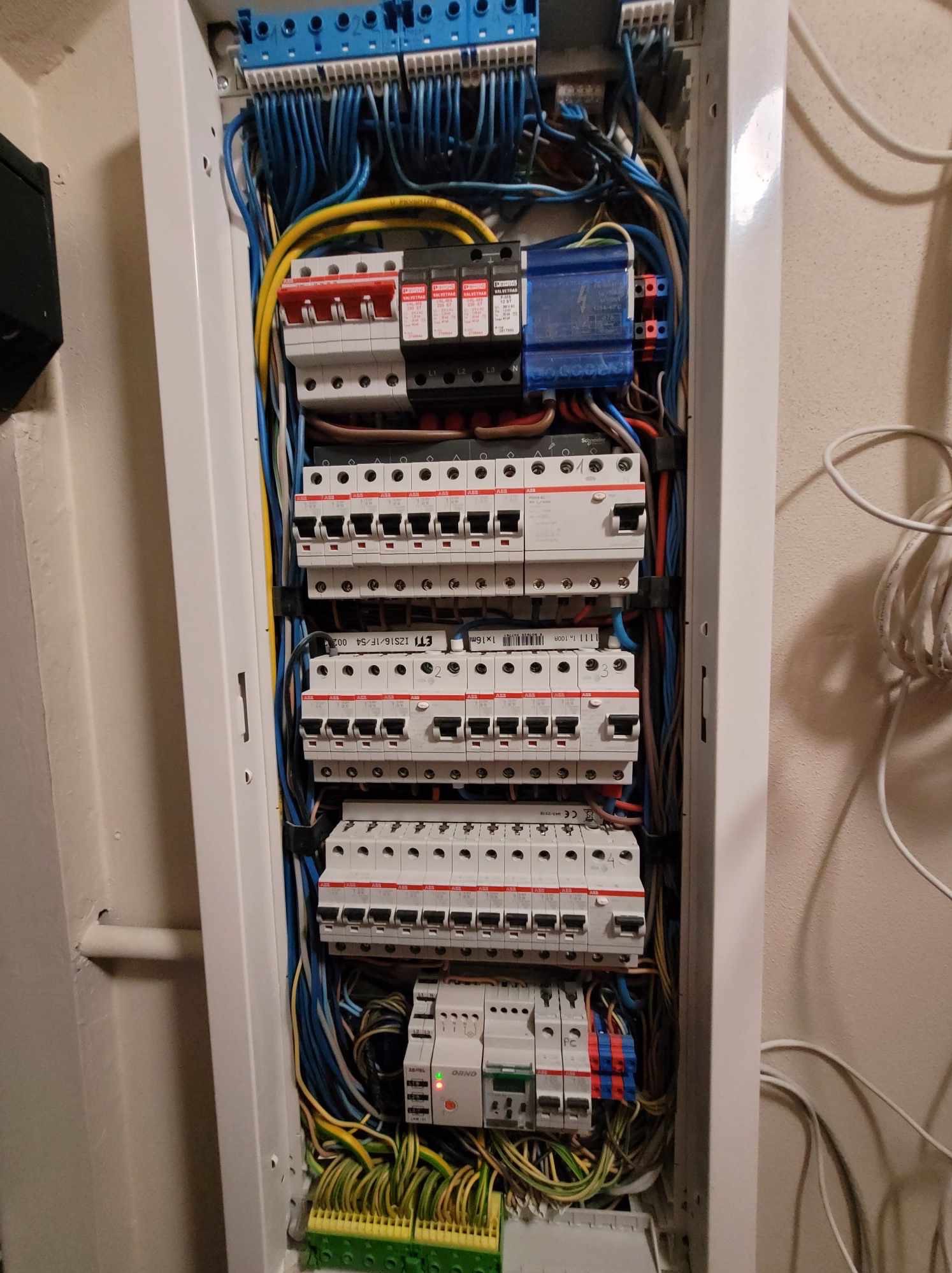 Otwarta skrzynka elektryczna z bezpiecznikami i okablowaniem w Buczkowicach, widoczne liczne przewody w różnych kolorach i osprzęt elektryczny.