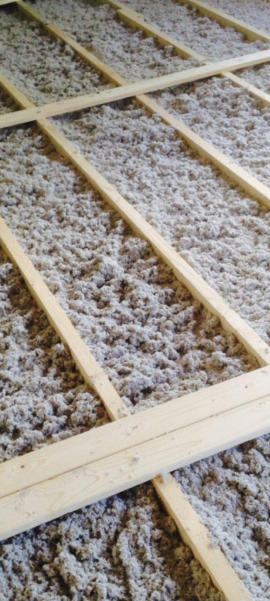 Ocieplenie poddasza wełną mineralną, widoczne drewniane legary konstrukcyjne. Etap prac przed zamknięciem izolacji.