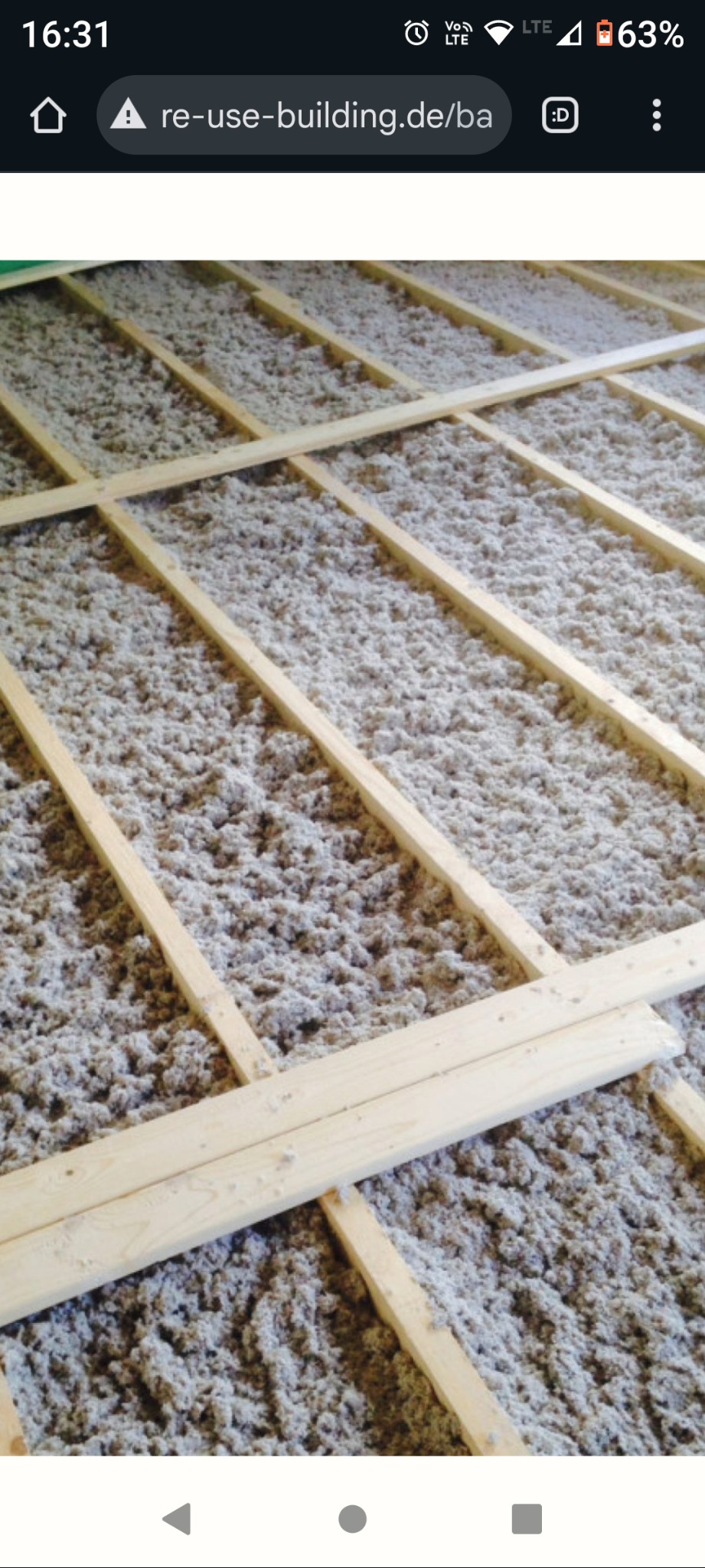 Izolacja poddasza wełną mineralną, widoczne drewniane legary. Etap prac przed zakryciem izolacji. Ujęcie z góry, oświetlenie naturalne.