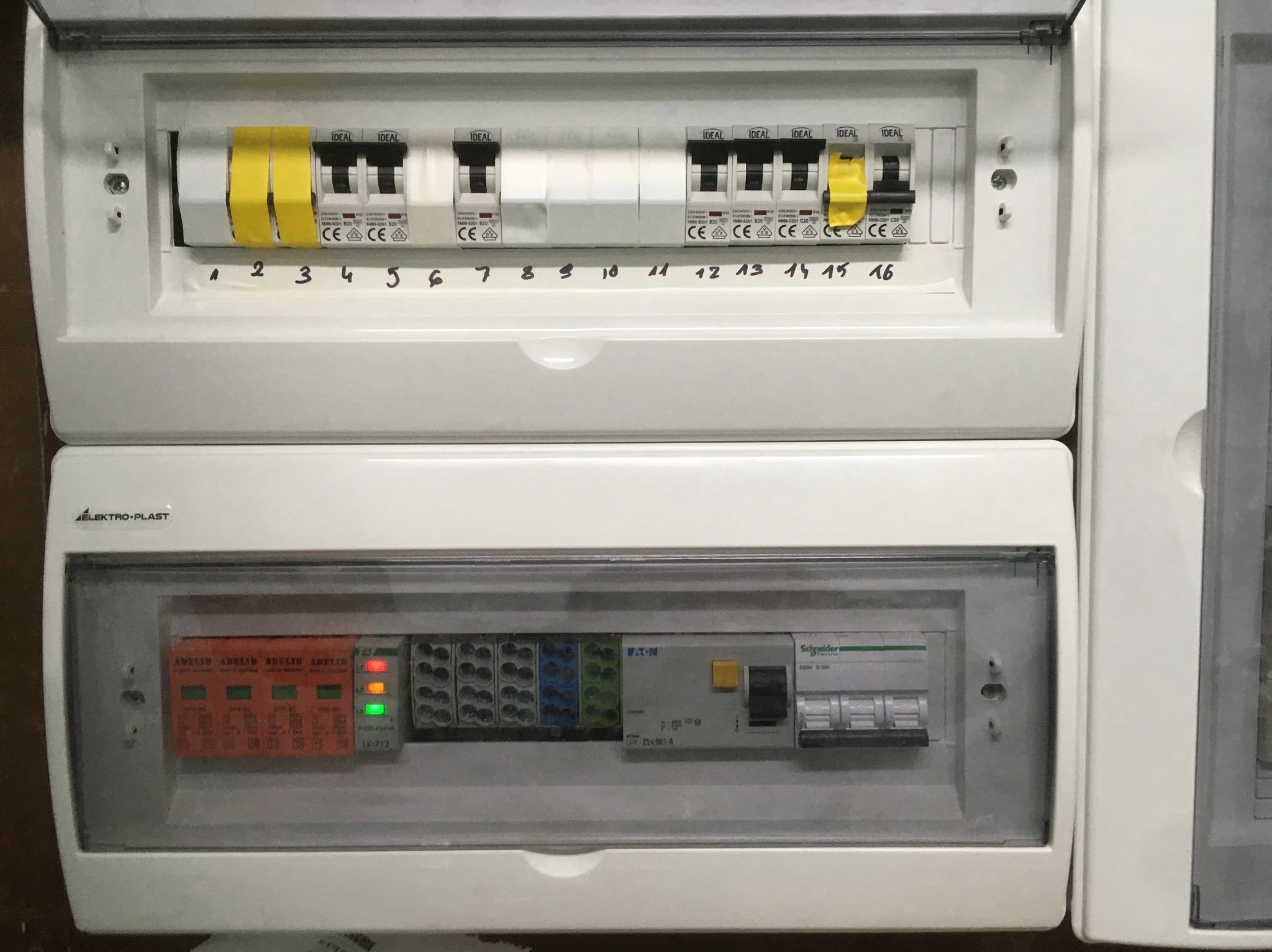 Rozdzielnia elektryczna z bezpiecznikami IDEAL, zabezpieczeniami przeciwprzepięciowymi ADELID z diodami LED i elementami firm Eaton oraz Schneider, opisana numerami od 1 do 16.
