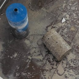 M.S INSTAL-MAT Usługi Hydrauliczne - Wykonanie otworu w podłodze pod instalacje. Widoczna wiertnica diamentowa i wycięty rdzeń. Prace hydrauliczne w trakcie realizacji, widoczne rury instalacyjne.