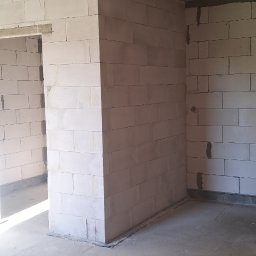 Domi-Rem - Wnętrze w trakcie budowy: surowy betonowy sufit, ściany z białych bloczków, widoczne spoiny. Minimalistyczny, industrialny klimat. Wnętrze do wykończenia.