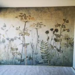 Ściana z fototapetą w motywy roślinne, imitująca akwarelę, zabezpieczona folią malarską na podłodze, widok na fragment okna i drzwi.