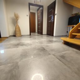 OnyxArt Piotr Padowski - Szara, duża płytka podłogowa w przedpokoju z drewnianymi schodami, widoczne drzwi wewnętrzne i dekoracyjny wazon.