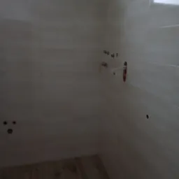 Świeżo wykafelkowana ściana łazienki z przygotowanymi punktami hydraulicznymi i elektrycznymi, widoczne wystające rurki i otwory na gniazdka.