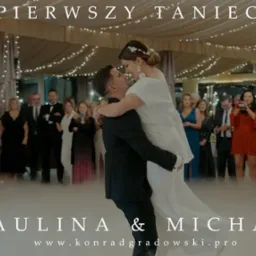 Para młoda podczas pierwszego tańca na weselu, unoszona przez pana młodego, otoczona gośćmi i efektem mgły, dekoracje świetlne w tle.