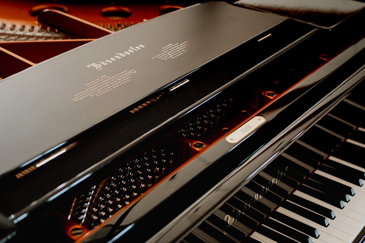 Wnętrze czarnego fortepianu marki Bösendorfer z widocznymi klawiszami i mechanizmem, sfotografowane w Ostródzie z bliska pod kątem.