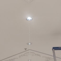 Electro Alpinist Dominik Wójcik - Biały sufit z dekoracyjną sztukaterią i oświetleniem punktowym, wyznaczonym laserowo, z fragmentem drabiny malarskiej w prawym dolnym rogu.