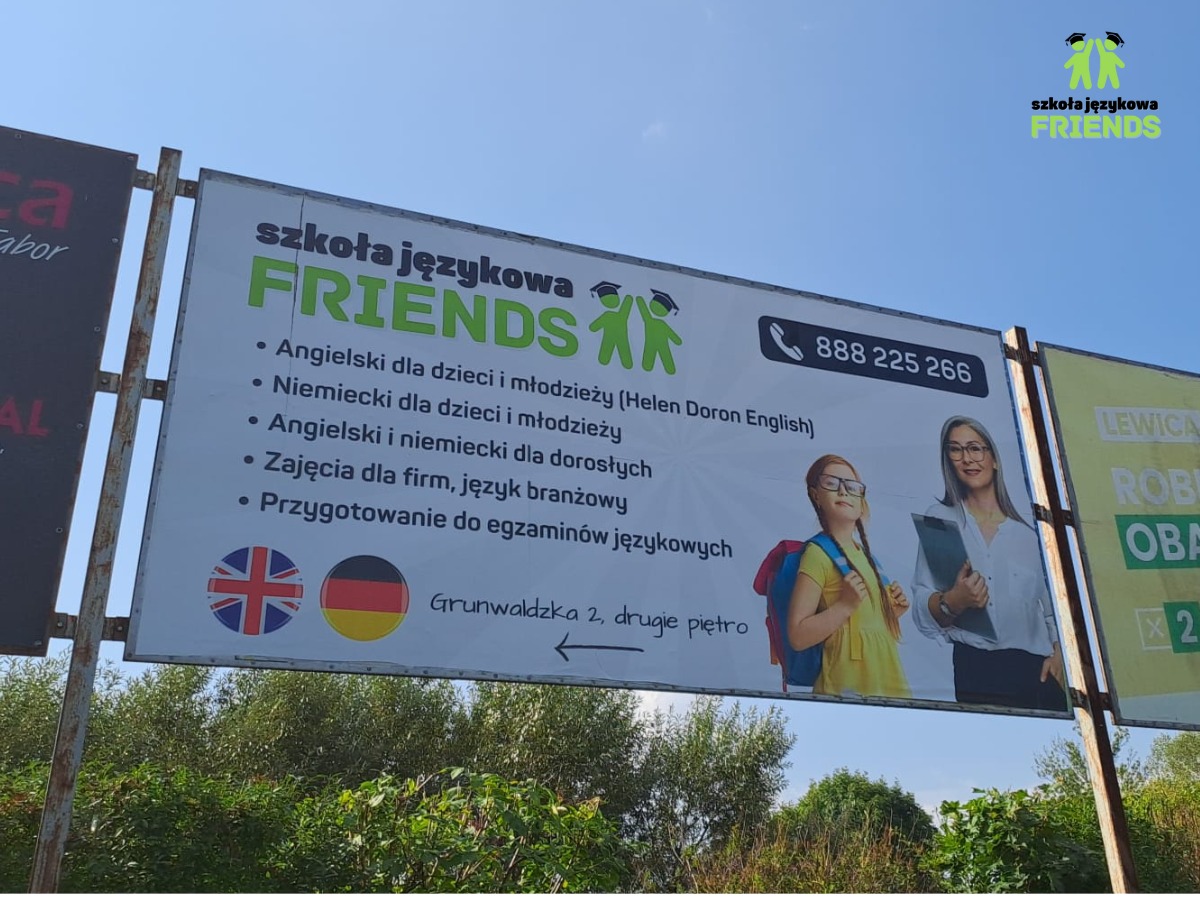 Billboard reklamujący szkołę językową Friends z ofertą kursów angielskiego i niemieckiego dla dzieci i dorosłych, zajęć dla firm oraz przygotowania do egzaminów językowych. Widoczne flagi Wielkiej...