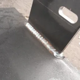 Detal spawu łączącego dwie metalowe płyty, widoczna struktura spoiny.