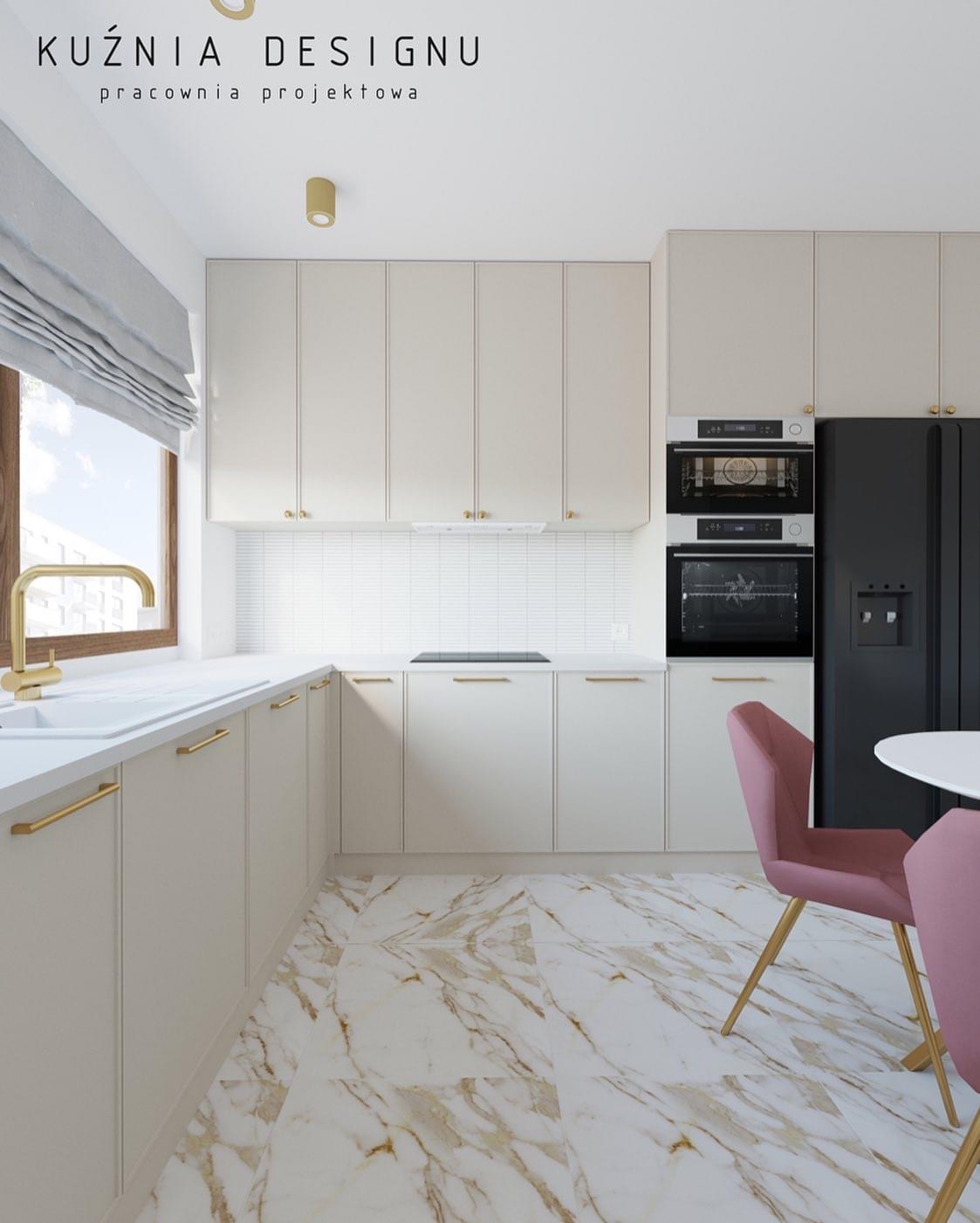 Jasna kuchnia z marmurową podłogą, złotymi akcentami i różowymi krzesłami, widok na zabudowę kuchenną z piekarnikiem i lodówką.