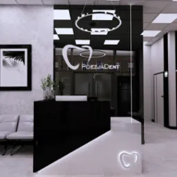 Nowoczesna recepcja w gabinecie stomatologicznym z czarno-białymi elementami, logo firmy podświetlone na ladzie, minimalistyczne meble i dekoracje.