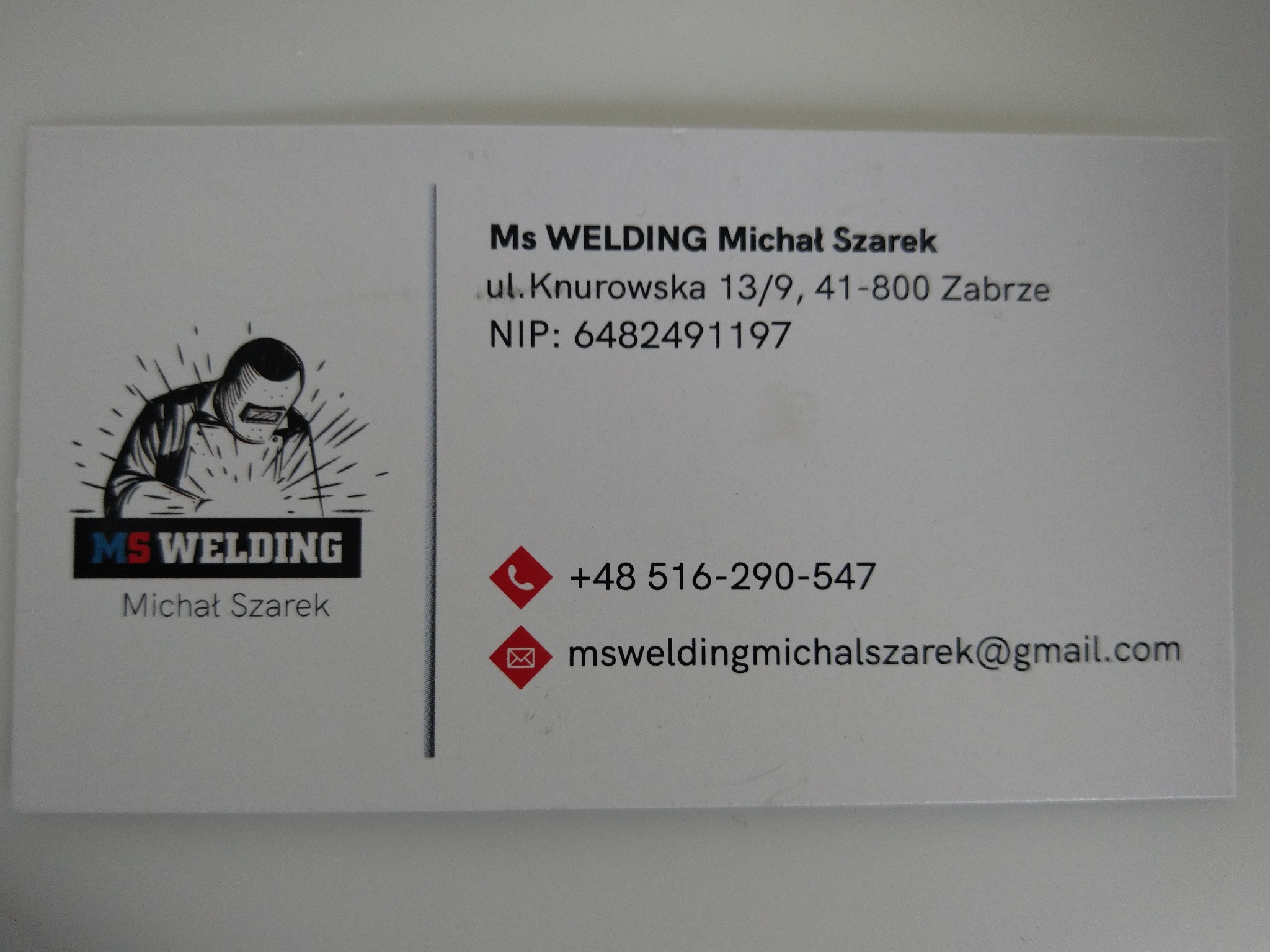 Wizytówka firmy MS WELDING Michał Szarek z adresem, numerem telefonu, adresem e-mail i graficznym logo przedstawiającym spawacza w masce.
