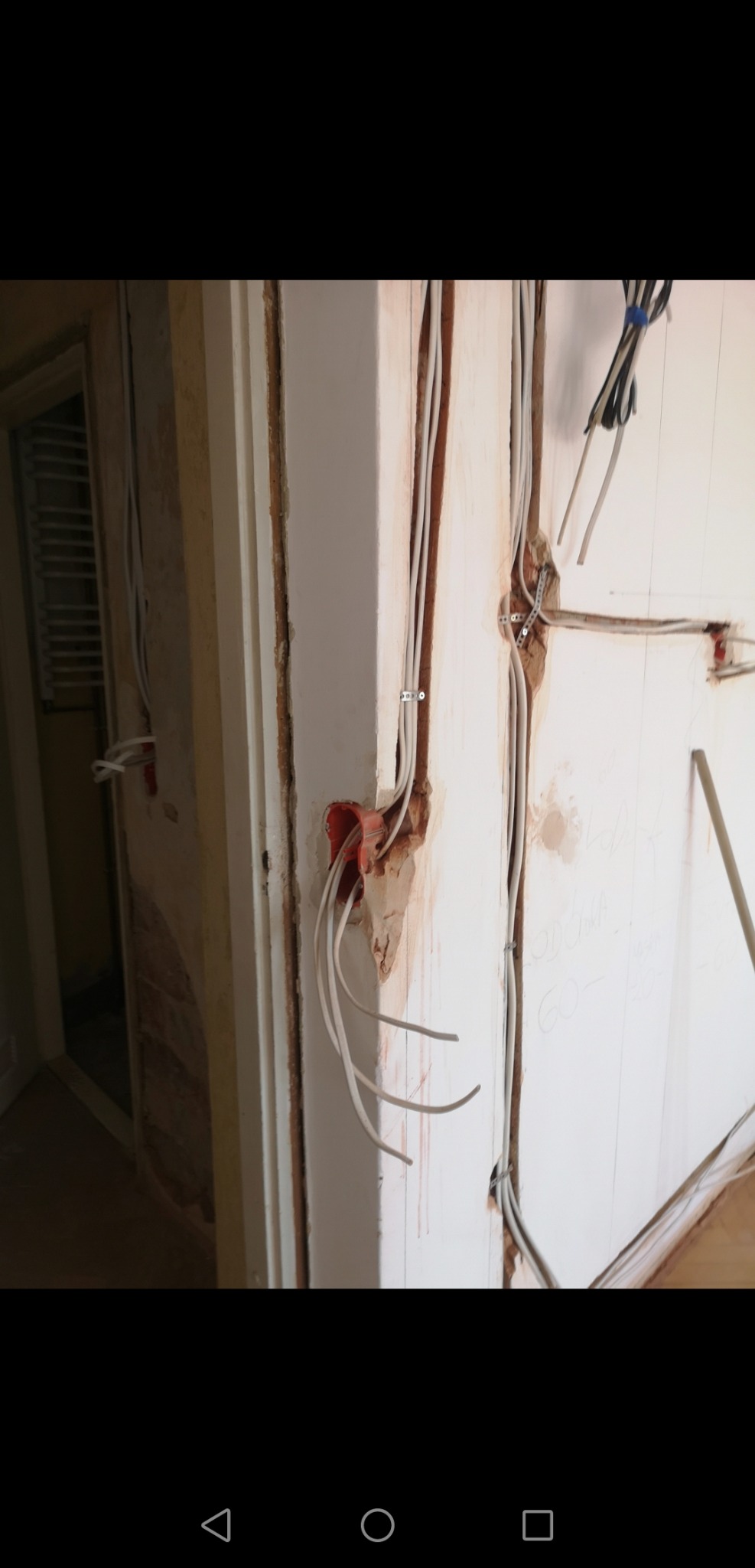 Instalacja elektryczna w trakcie remontu: widoczne przewody w ścianie, puszka instalacyjna i ślady po kuciu.