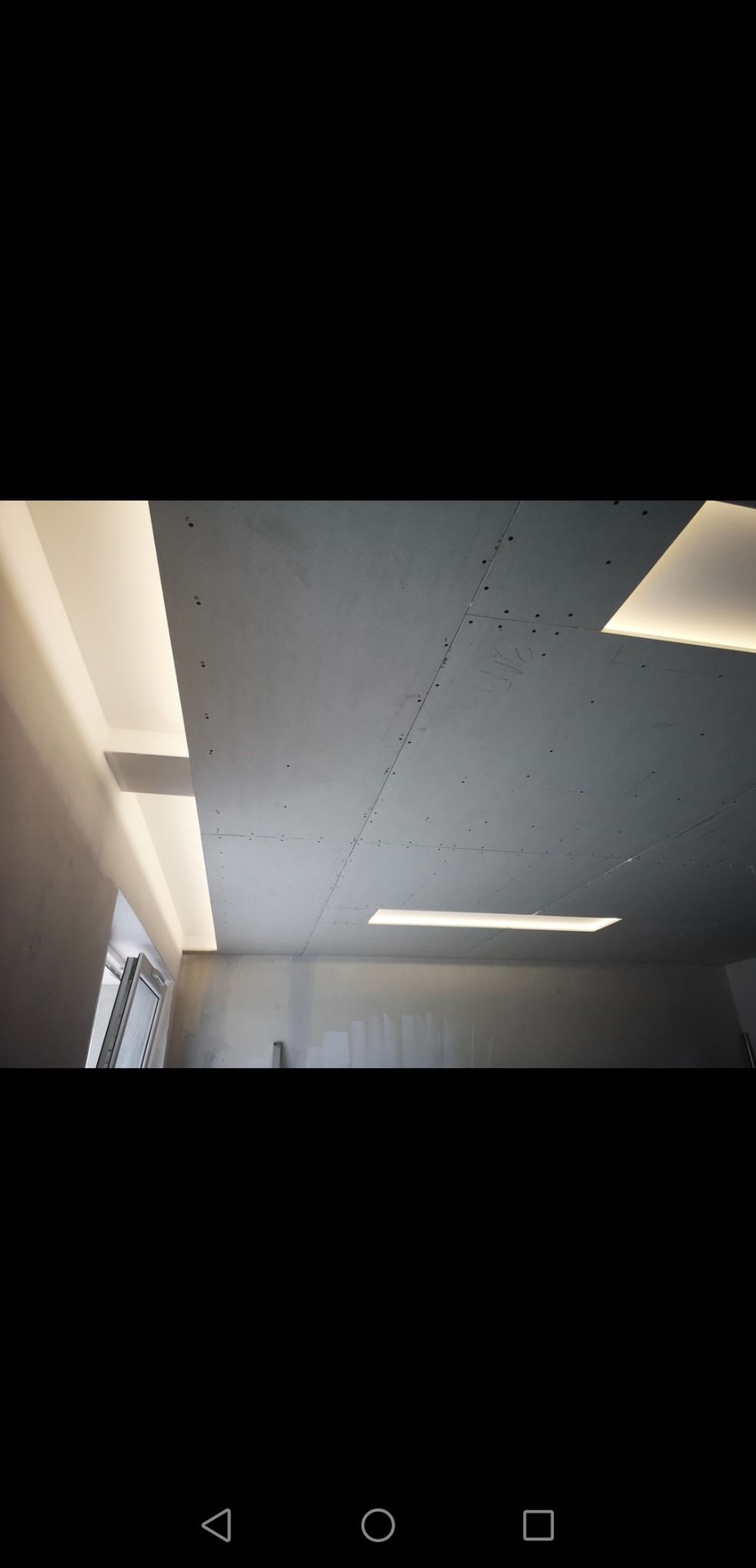 Sufit podwieszany z płyt kartonowo-gipsowych z wbudowanym oświetleniem LED, widoczne łączenia płyt przed szpachlowaniem.