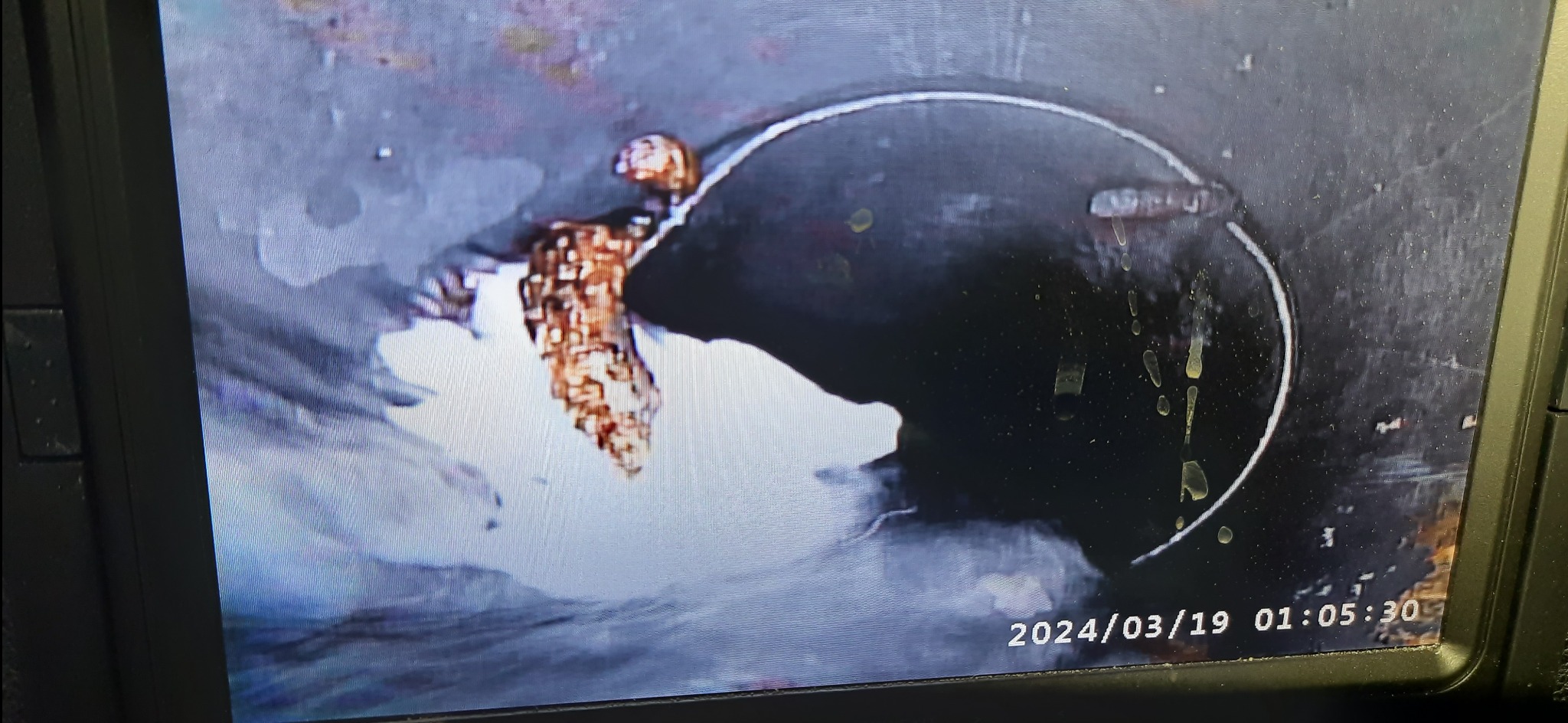 Wewnętrzny widok rury kanalizacyjnej z zatorami i osadami, zarejestrowany kamerą inspekcyjną z datą 2024/03/19 01:05:30.