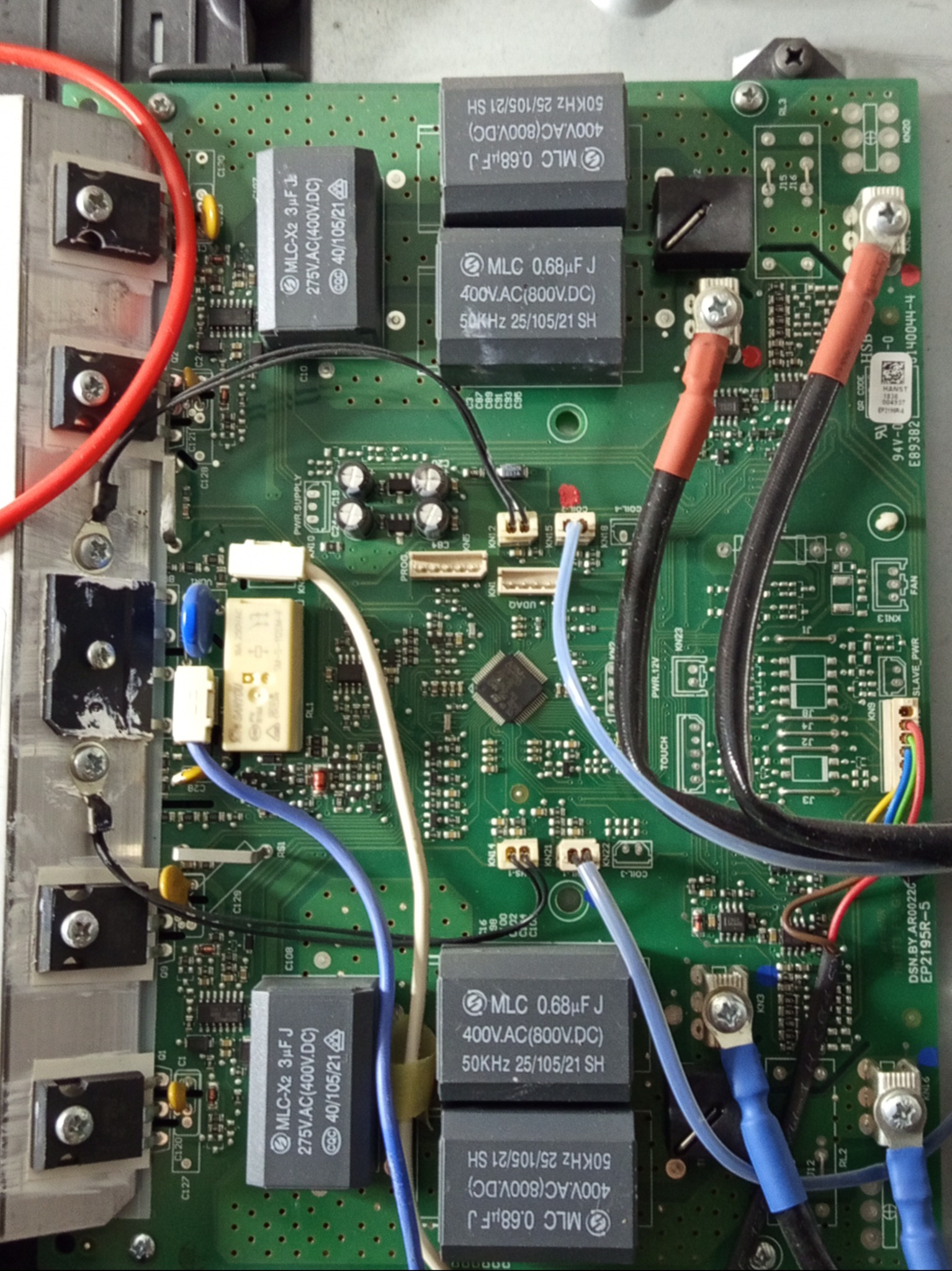 Płyta indukcyjna Beko po naprawie modułu mocy i zasilacza. Widoczne elementy elektroniczne, kondensatory, przewody i śruby mocujące. Detaliczne ujęcie naprawionej elektroniki.