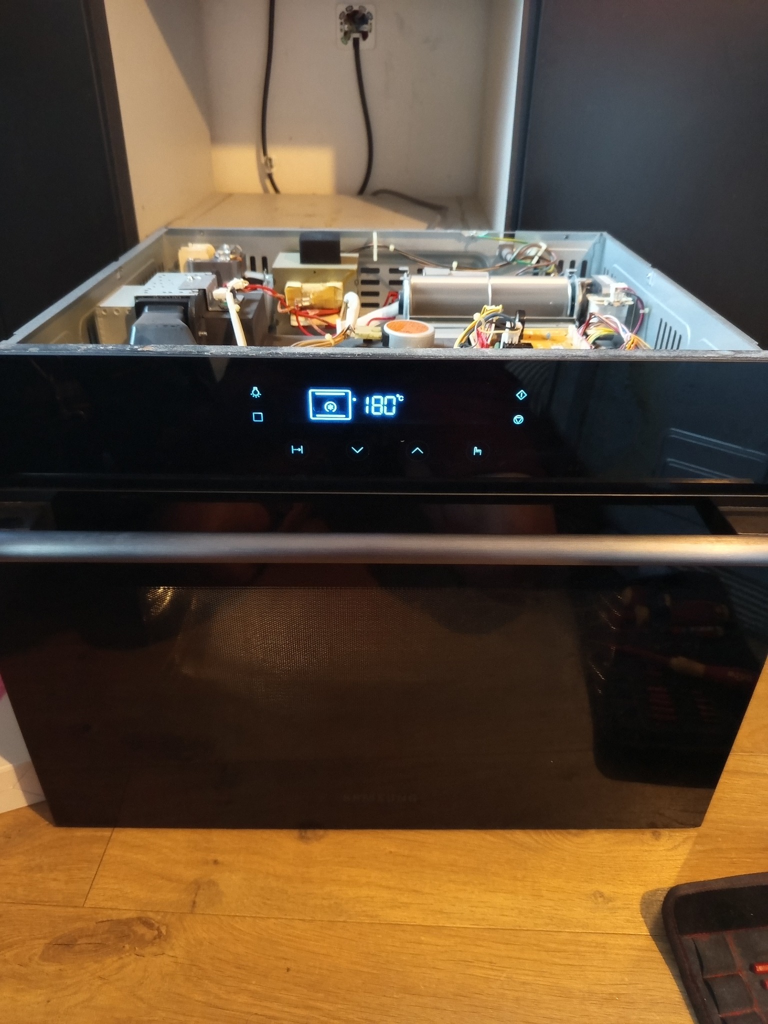 Piekarnik Samsung Combi z otwartą obudową, widoczne elementy elektroniki. Usługa naprawy piekarników w Kiełczowie. Wyświetlacz pokazuje 180 stopni.