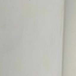 BoTom Tomasz Bogusz - Gładka, biała ściana w rogu pomieszczenia, z delikatnymi smugami i niedoskonałościami, ukazująca efekt końcowy prac wykończeniowych. Widoczne elementy instalacji grzewczej przy podłodze.