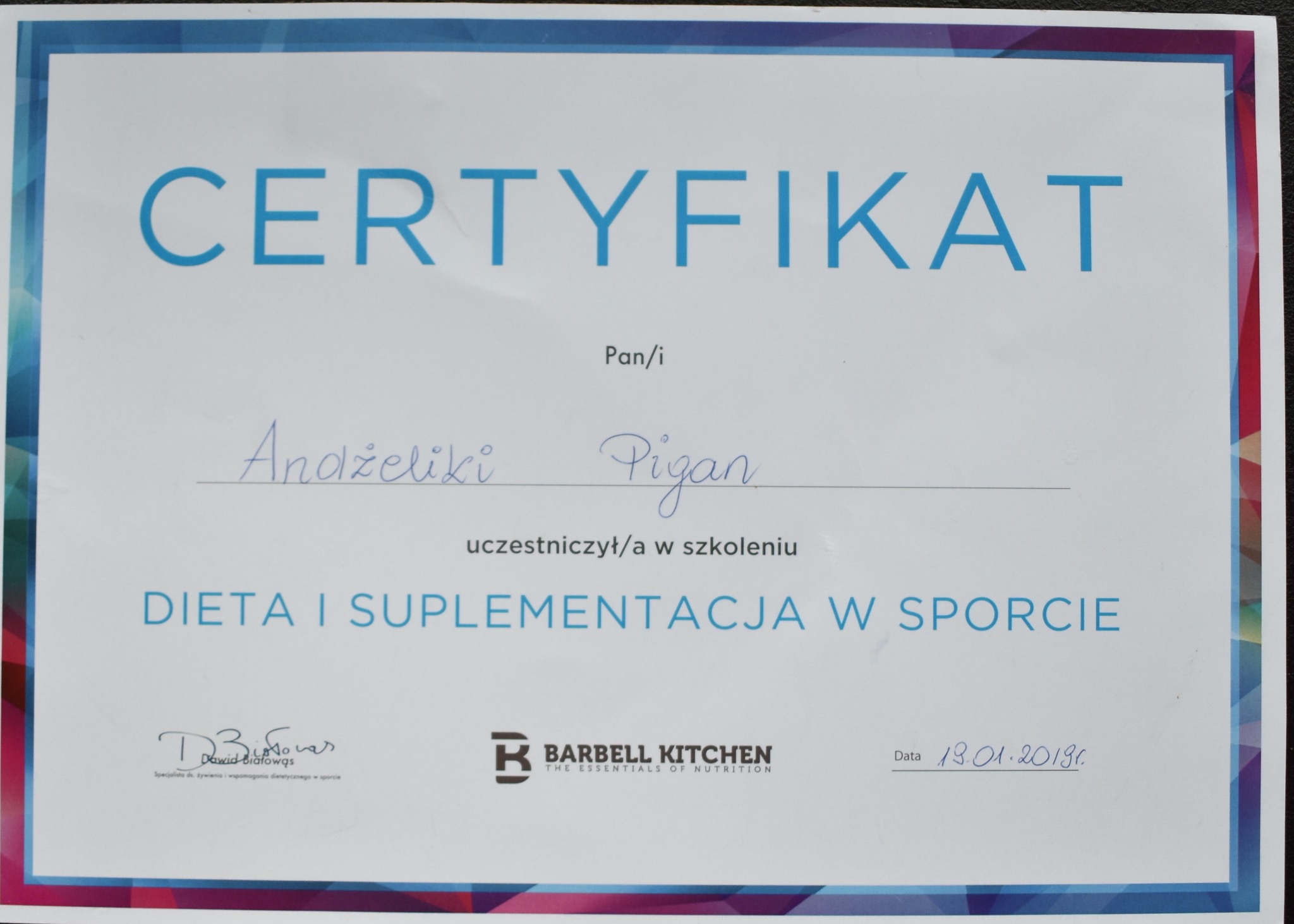Certyfikat ukończenia szkolenia z zakresu diety i suplementacji w sporcie dla Andżeliki Pigan, sygnowany przez Barbell Kitchen i Dawida Białowąsa.