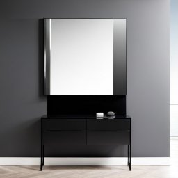 KROYEE Sp. z o.o. - Czarna, lakierowana konsola z szufladami i lustrem w minimalistycznym stylu, na blacie białe pudełko i szary kamień dekoracyjny, jasna podłoga, szara ściana, widok na zewnątrz.