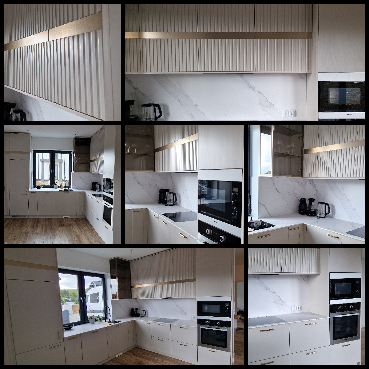 Jasna kuchnia z białymi frontami szafek z frezowanymi pionowymi liniami i złotymi akcentami, marmurowy backsplash, nowoczesne sprzęty AGD w zabudowie, widok na okno i drewnianą podłogę.