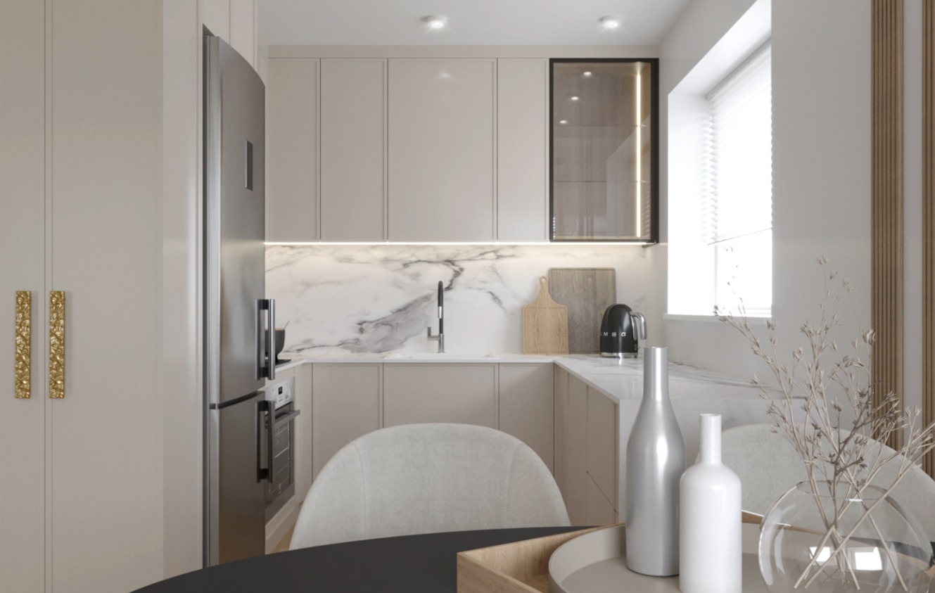 Jasna kuchnia w stylu minimalistycznym z marmurowym blatem, zabudową meblową pod sufit, złotymi uchwytami i srebrną lodówką; na stole dekoracyjne butelki i szklany wazon z suchymi gałązkami.