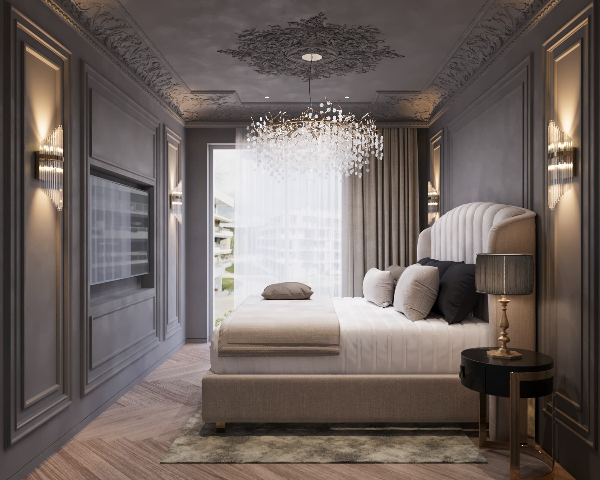Elegancka sypialnia w odcieniach szarości z dekoracyjnymi sztukateriami na suficie i ścianach, kryształowy żyrandol nad łóżkiem, dwie szklane lampy ścienne po bokach telewizora wbudowanego w ścianę.