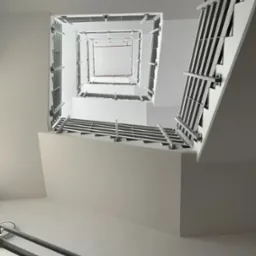 Wnętrze klatki schodowej z widokiem w górę, białe ściany i metalowe barierki, perspektywa z dołu tworzy efekt tunelu.