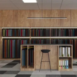 Wnętrze biura z ekspozycją próbek tkanin na drewnianych regałach, czarny hoker przed blatem, podłoga w szachownicę, widok na przeszklone pomieszczenie w tle.