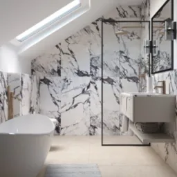 Elegancka łazienka na poddaszu z marmurowymi płytkami, owalną wanną i kabiną prysznicową ze złotą armaturą, doświetlona oknem dachowym.