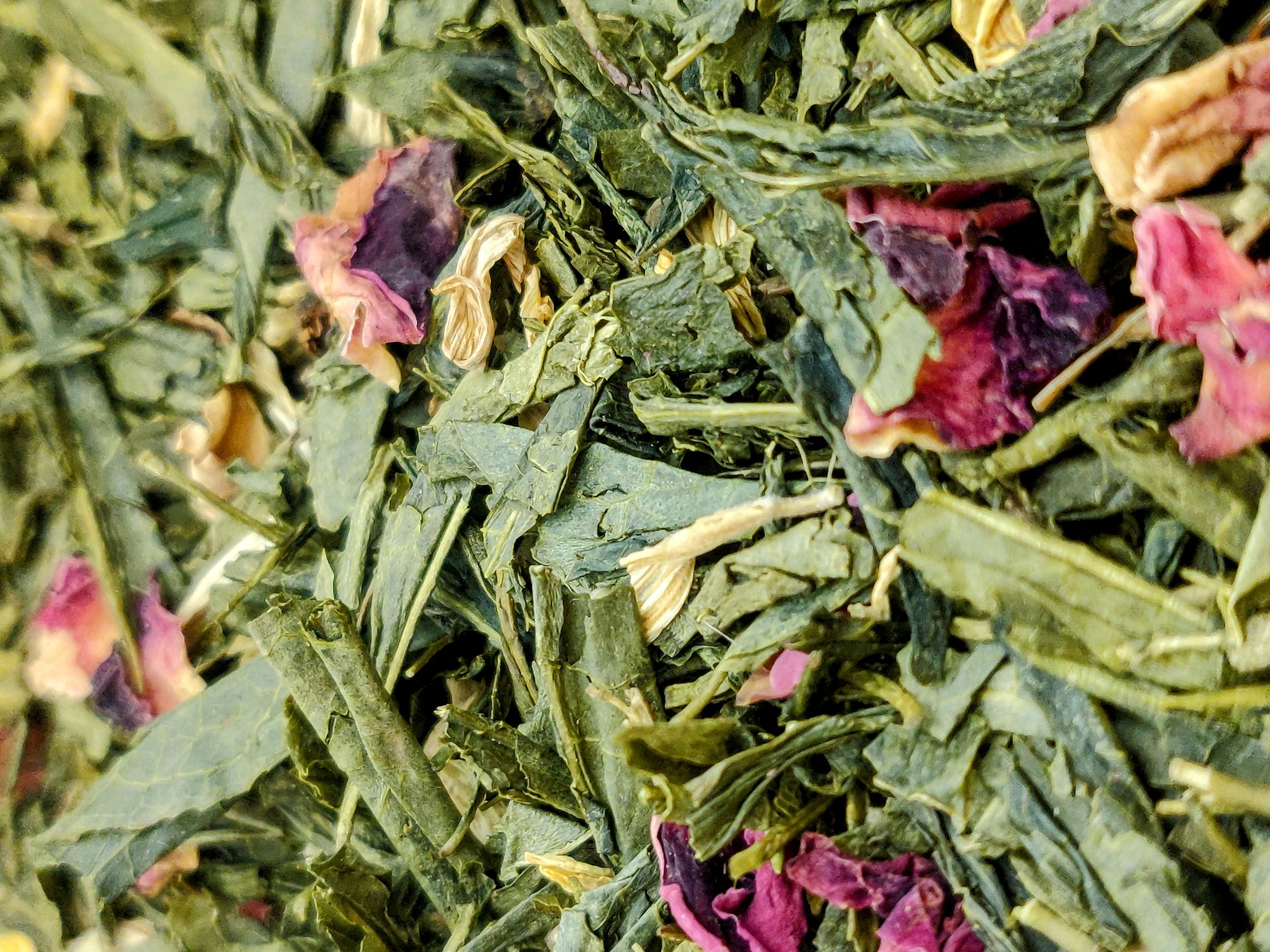 Susz herbaciany: zielone liście i płatki róż w zbliżeniu, z widoczną strukturą i detalami.