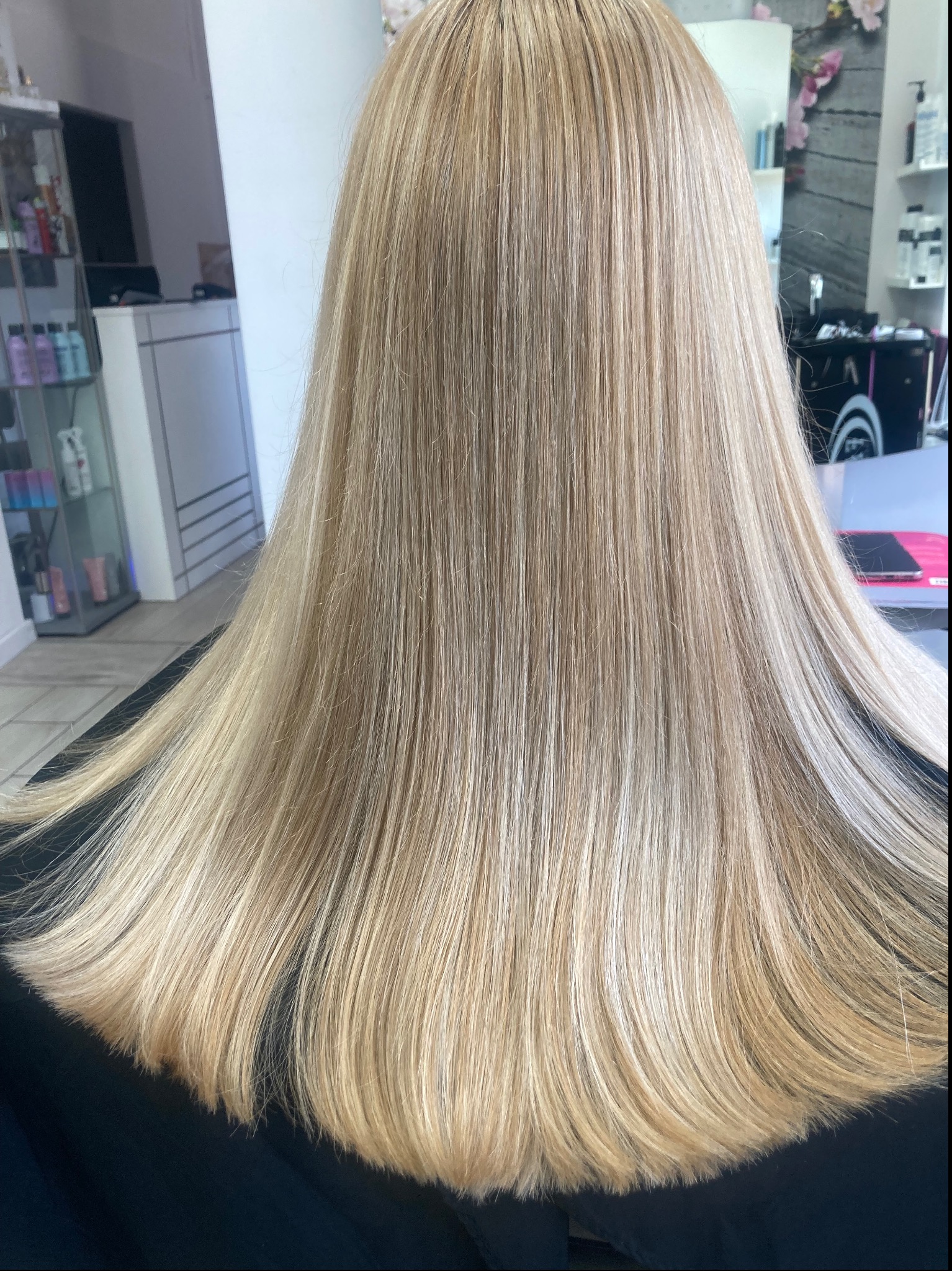 Tył głowy z długimi, prostymi włosami w odcieniach blondu, świeżo po koloryzacji i strzyżeniu, widoczne delikatne cieniowanie końcówek.