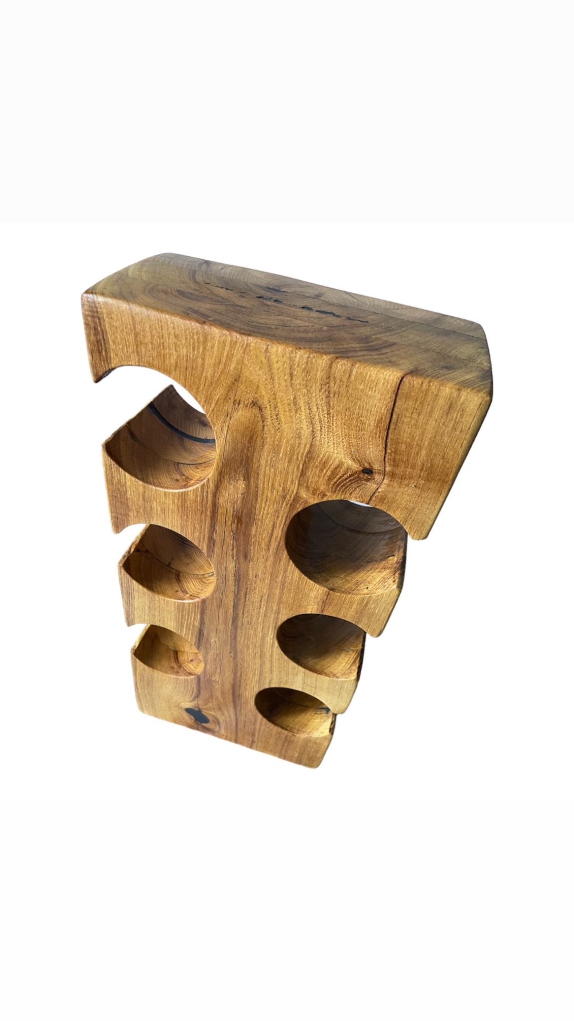 Ręcznie wykonany, rustykalny stojak na wino z litego drewna z widocznymi słojami i naturalnymi pęknięciami, z sześcioma okrągłymi otworami na butelki, na białym tle.