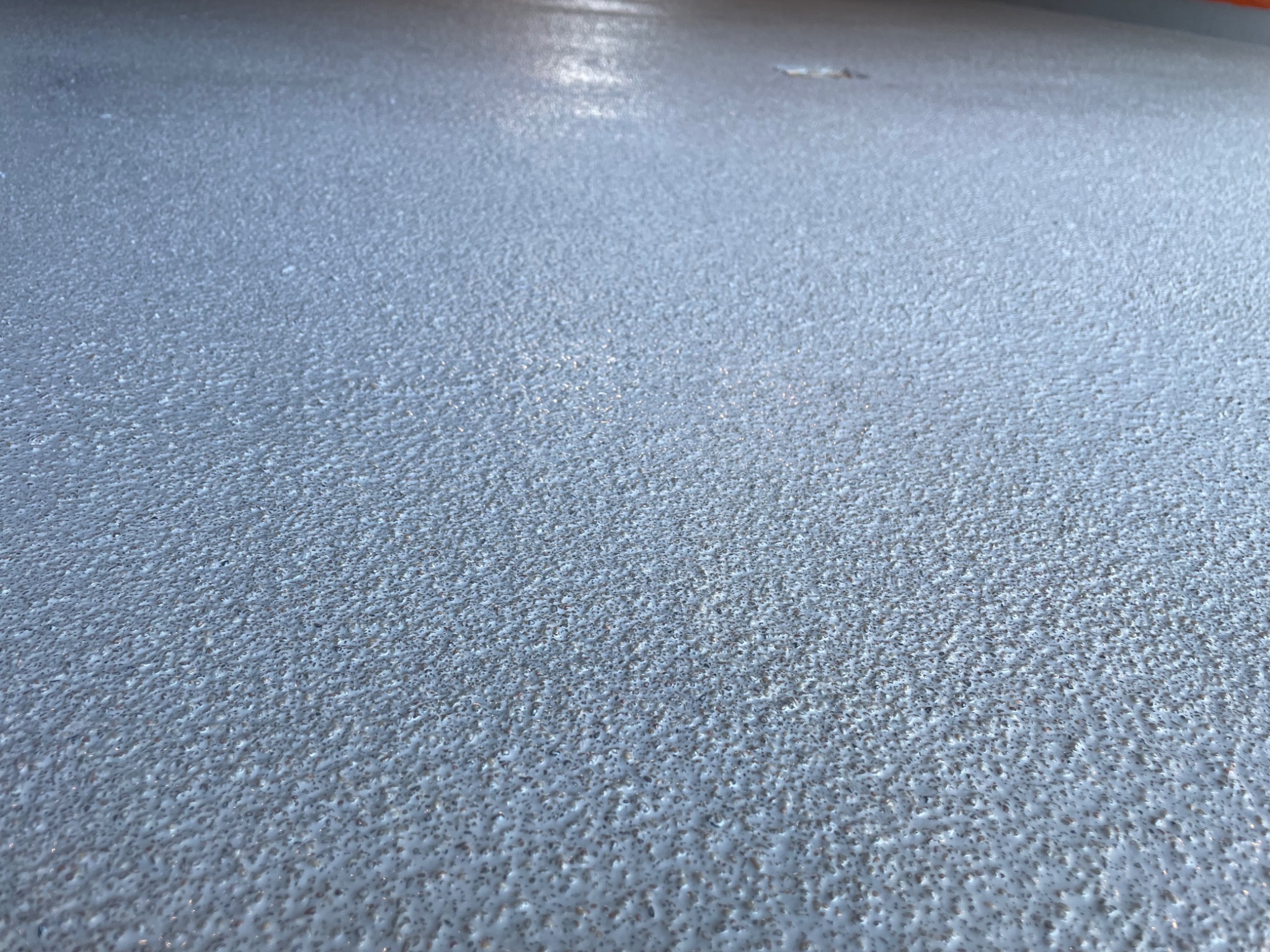 Szpachlowana powierzchnia podłogi z widoczną fakturą 'baranka' i delikatnym połyskiem, świeżo po nałożeniu.