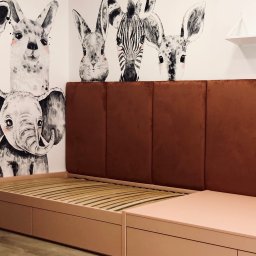 LAMAR meble - Różowe łóżko z brązowym wezgłowiem na tle ściany z rysunkami zwierząt. Nowoczesny design, widoczne detale ramy i stelaża. Ujęcie z bliska, podkreślające estetykę mebla.