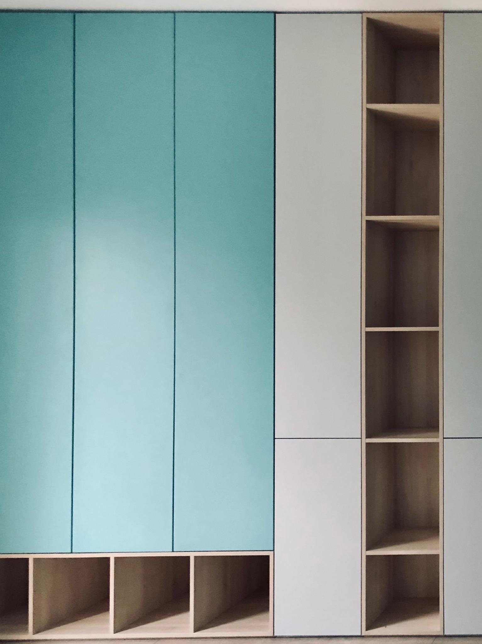 Błękitno-biała szafa wnękowa z otwartymi półkami z jasnego drewna, minimalistyczny design, nowoczesne wykończenie, widok z bliska.