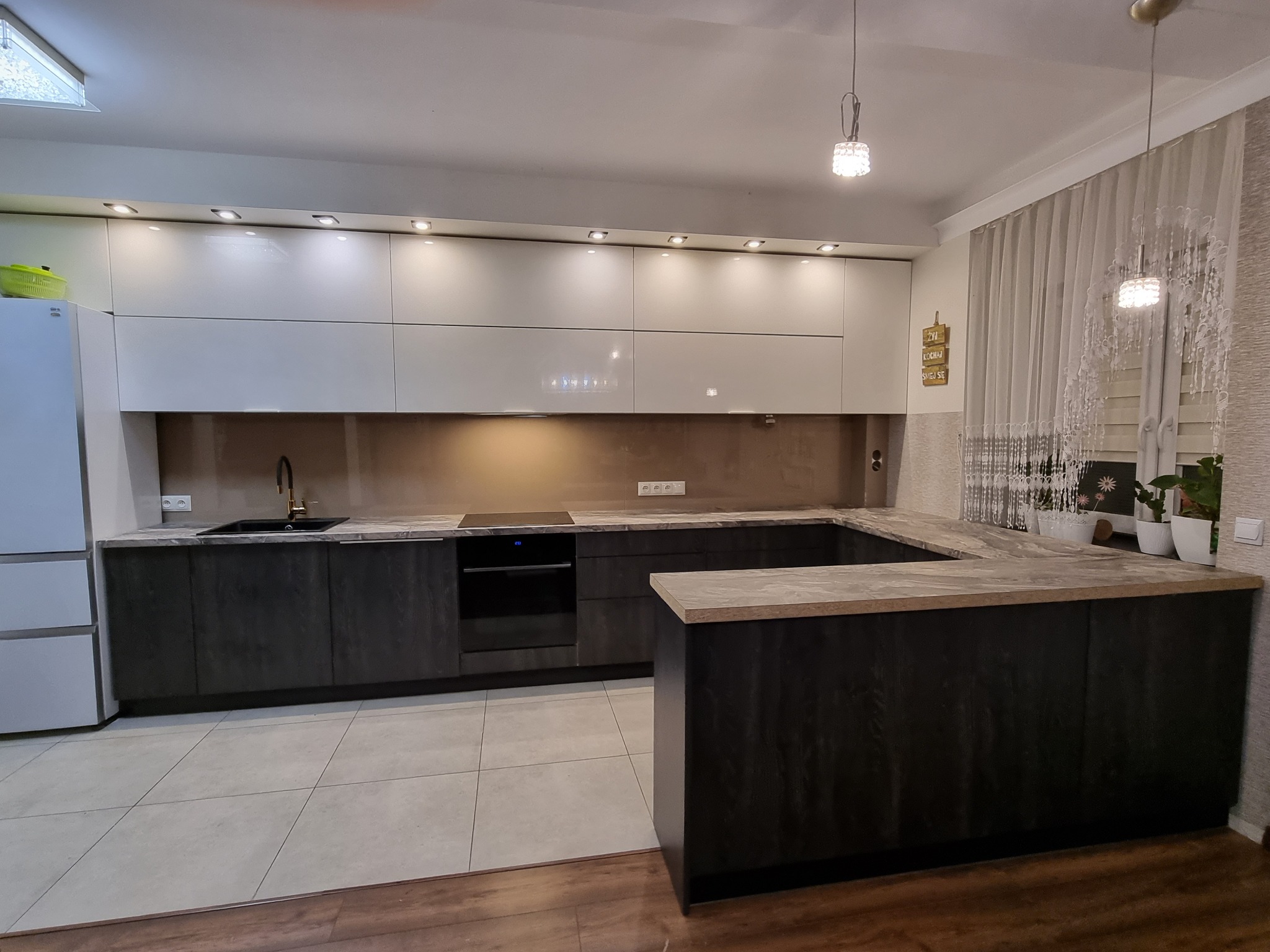 Zabudowa kuchni ciemnym drewnianym dekorze