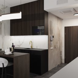 APART DESIGN - Nowoczesna kuchnia z wyspą, czarnymi szafkami i marmurowymi ścianami, oświetlona listwą LED pod szafkami i lampą wiszącą, z elementami dekoracyjnymi jak wino i naczynia na wyspie oraz trawa...