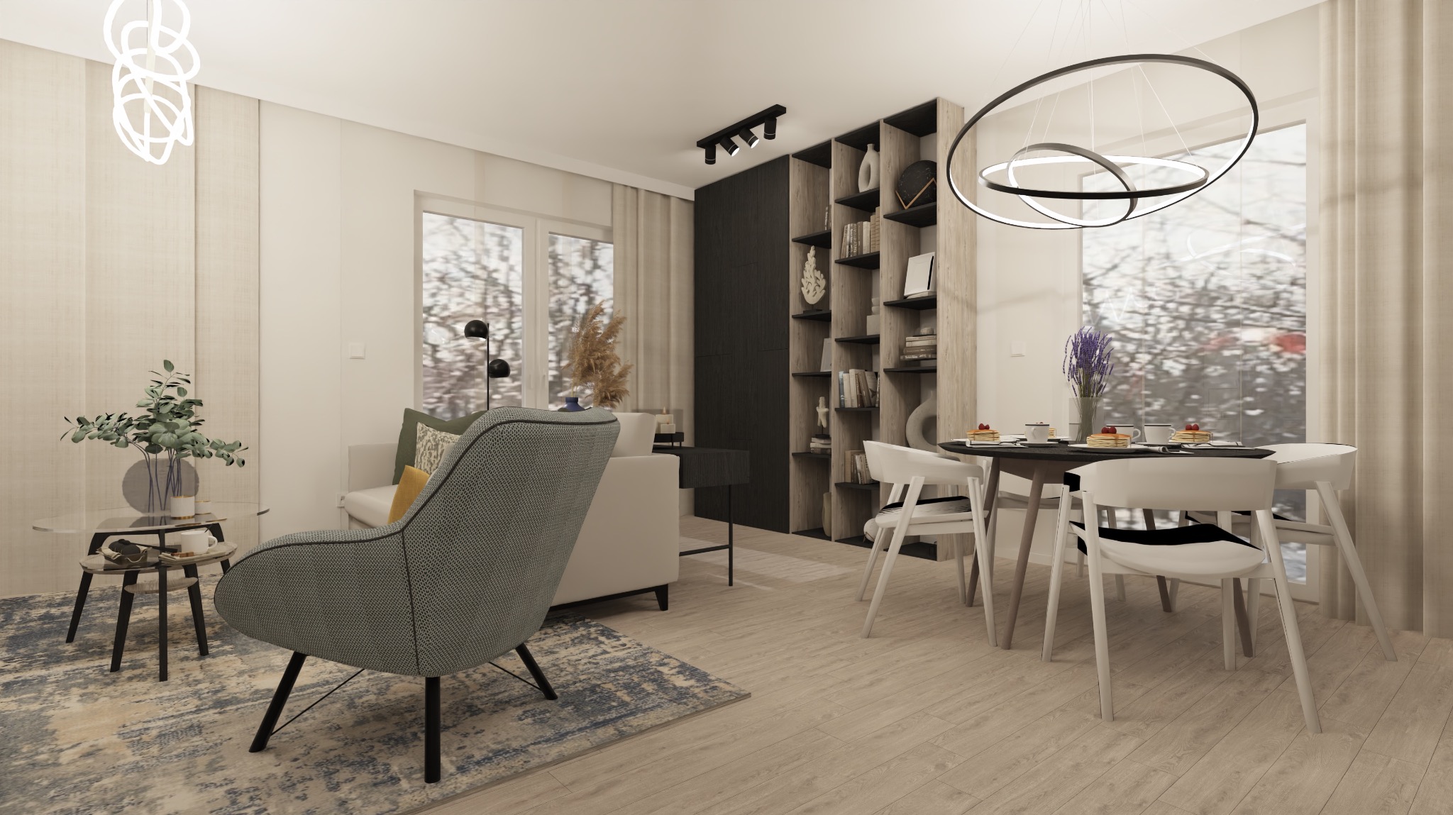 Jasne wnętrze mieszkania z szarym fotelem, białym narożnikiem, regałem z książkami i okrągłym stołem z deserami przy oknie.