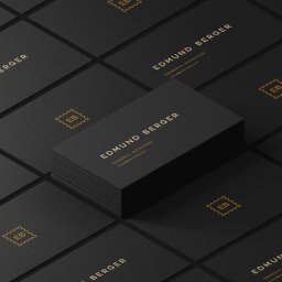 Marcin Konopnicki Portfolio - Elegancki zestaw czarnych wizytówek z tłoczonym złotym tekstem i logo układający się w geometryczny wzór.