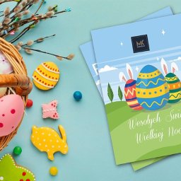 Marcin Konopnicki Portfolio - Wielkanocna kompozycja z koszykiem pełnym malowanych jajek, ciasteczek w kształcie jajek i zwierząt oraz ulotek z życzeniami świątecznymi.