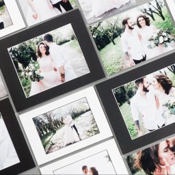 Marcin Konopnicki Portfolio - Kolekcja wydrukowanych fotografii ślubnych w białych i czarnych ramkach, prezentująca parę w plenerze.