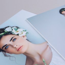 Marcin Konopnicki Portfolio - Dwa wydrukowane zdjęcia portretowe kobiety z kwiatami we włosach, ujęcie z bliska, widoczne detale makijażu i faktura papieru.
