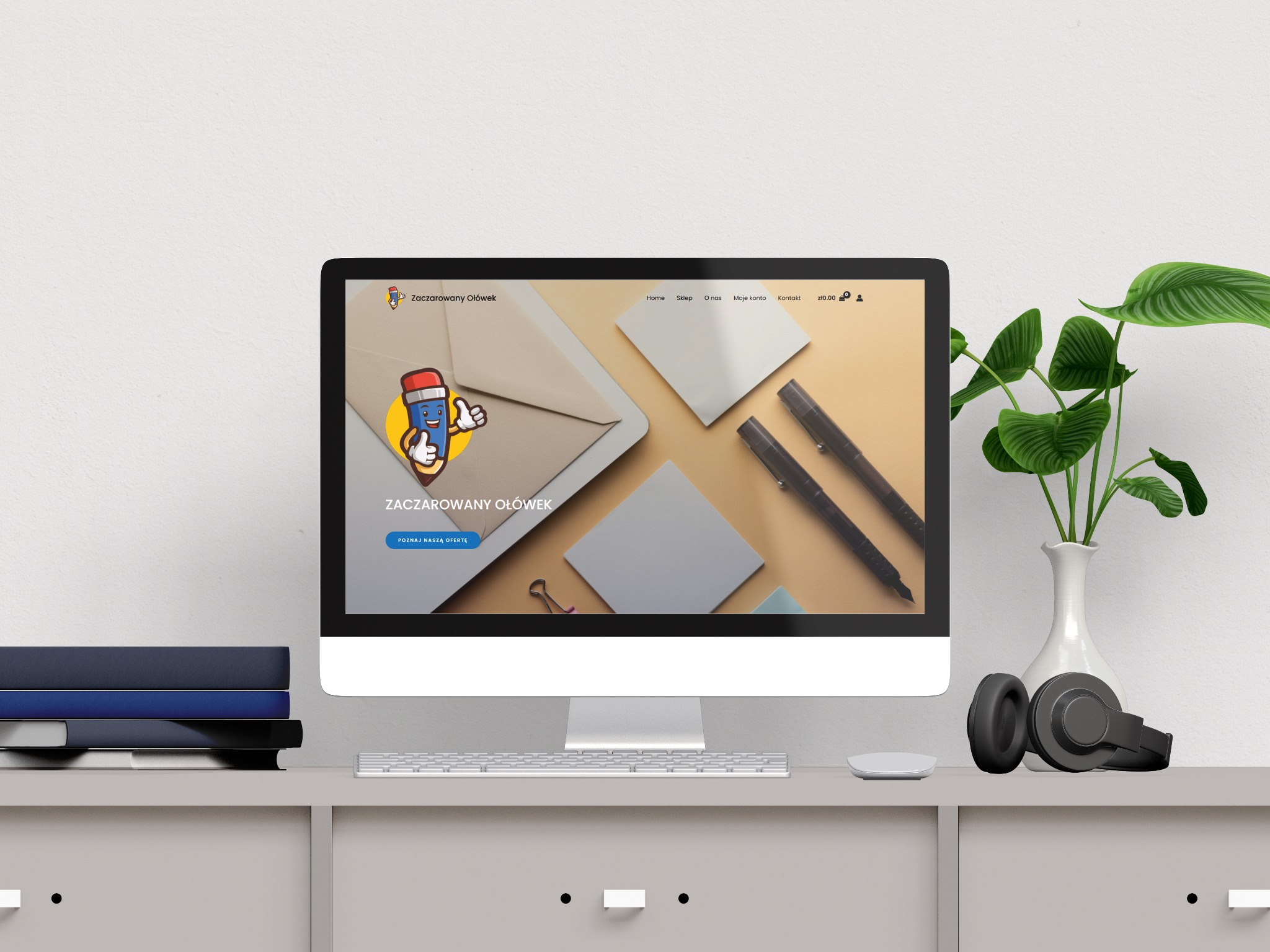 Strona internetowa 'Zaczarowany Ołówek' na monitorze, obok słuchawki i wazon. Minimalistyczny design w Płotach. Maskotka ołówka z kciukiem w górę.